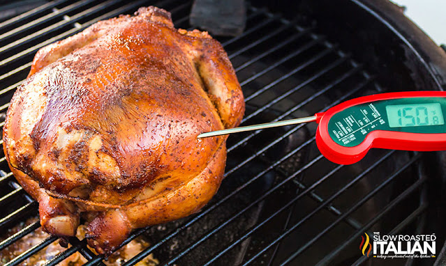 checking internal temperature of smoked whole chicken