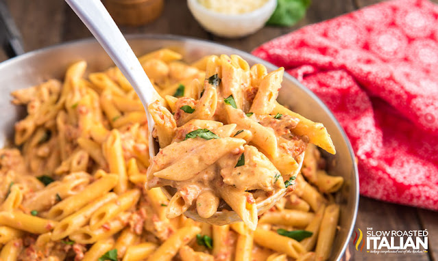 serving spoon in bowl of chicken penne pasta