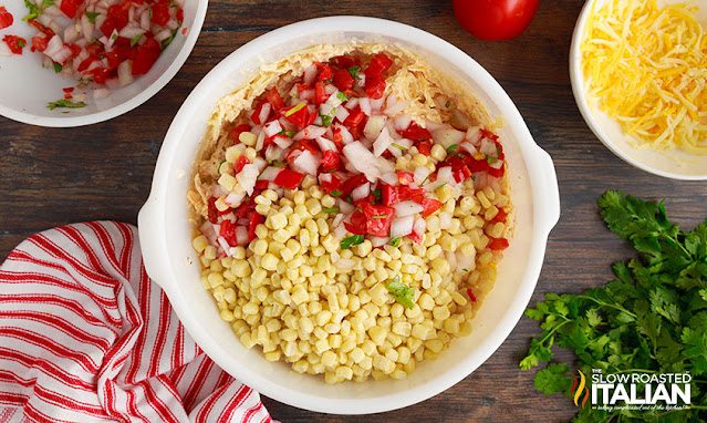 adding pico de gallo to mixing bowl of leftover corn