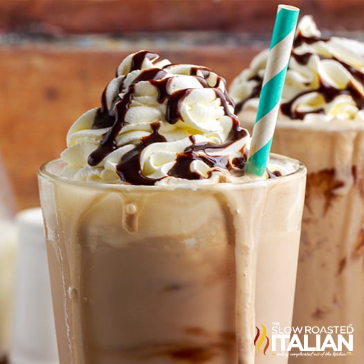 coffee milkshake in tall glass with whipped cream and chocolate syrup