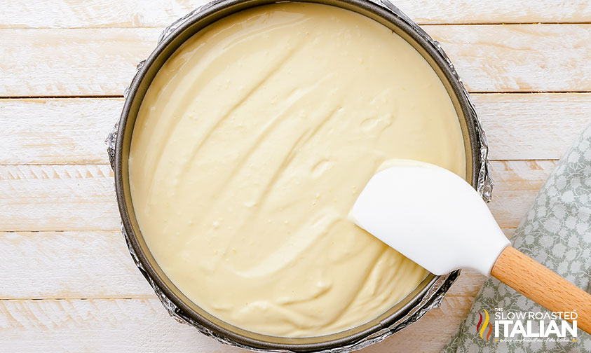 smoothing cream cheese dessert filling into springform pan