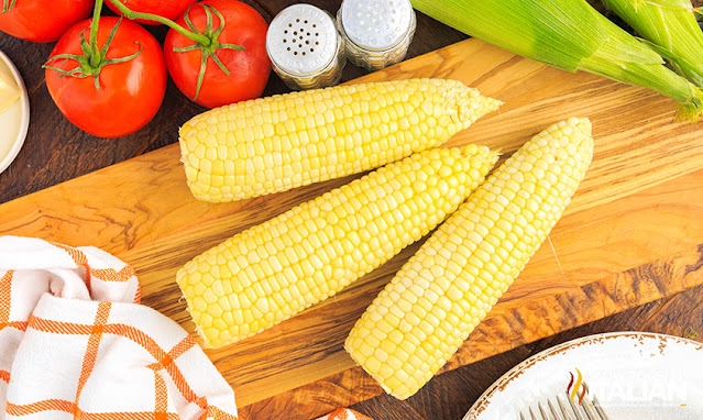 overhead: 3 pieces microwave corn on the cob on wood cutting board