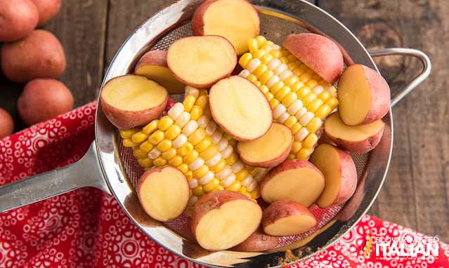 corn on the cob and red potato halves in a strainer