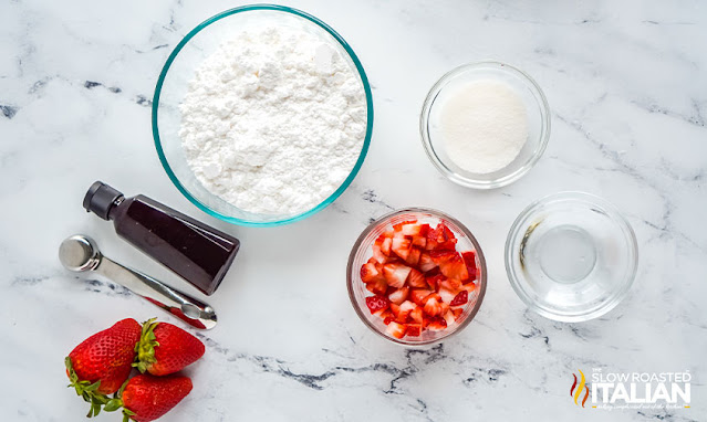 strawberry icing ingredients in small bowls on marble counter
