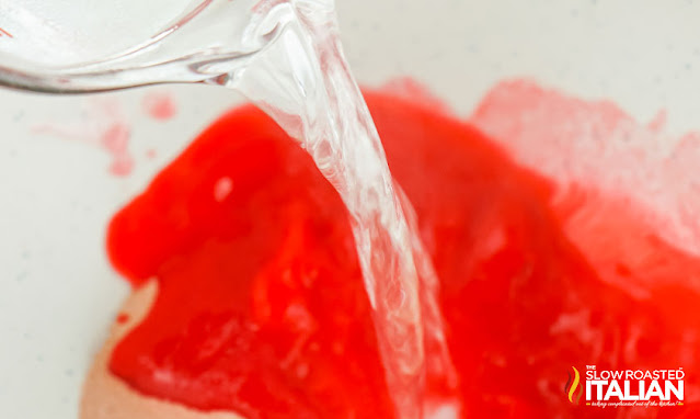 pouring water into red gelatin powder