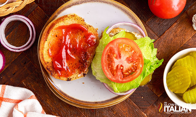 overhead: hamburger bun open faced with ketchup, lettuce and tomato
