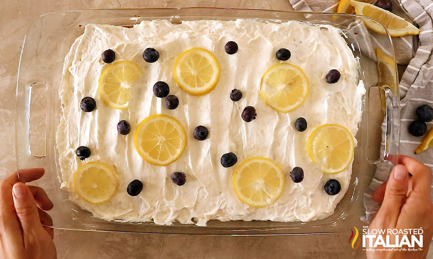 overhead: lemon slices and blueberries on frosted dessert