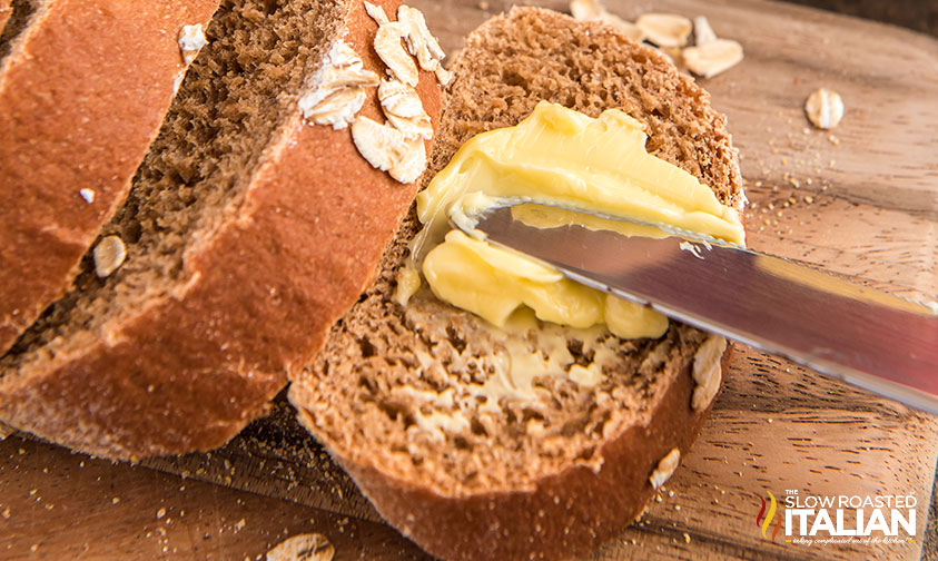 close up of knife spreading butter on slice of Cheesecake Factory brown bread