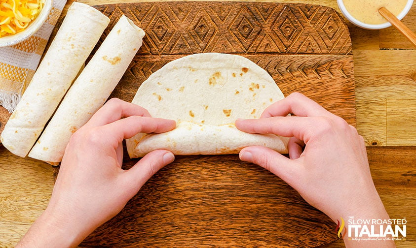 rolling up flour tortillas for Mexican appetizers