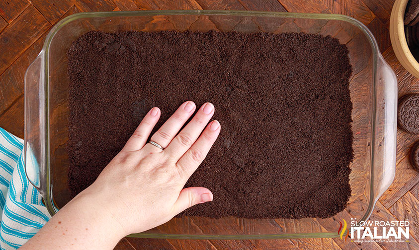 pressing chocolate cookie crumbs into bottom of casserole dish