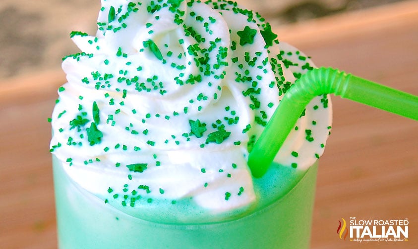 green milkshake topped with whipped cream and green sprinkles