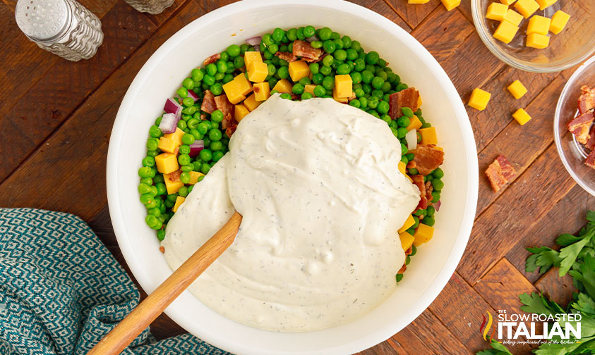 stirring ranch dressing into vegetable salad