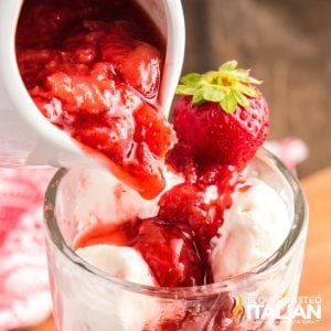 pouring strawberry dessert sauce onto vanilla ice cream