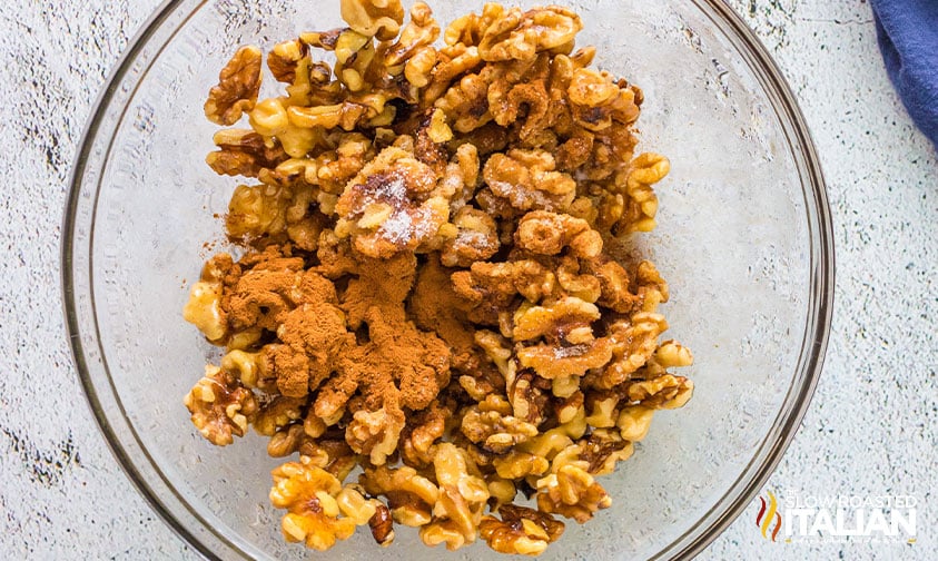 nuts tossed with cinnamon and spices in glass bowl