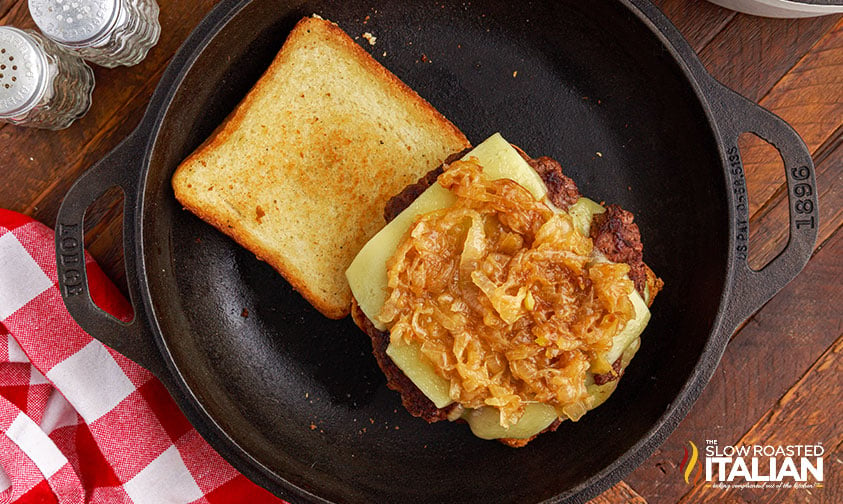 overhead: caramelized onions and cheese on toasted bread in skillet