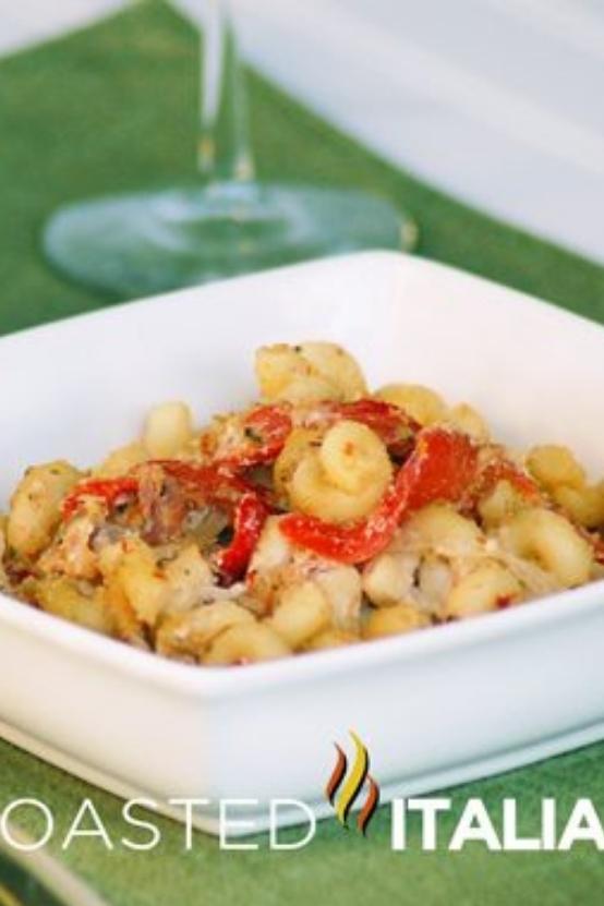 pasta dinner in white bowl next to wine glass.