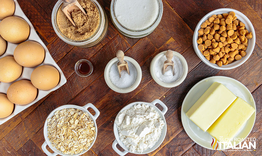 bowls of flour, sugar and oats on counter next to butter and eggs