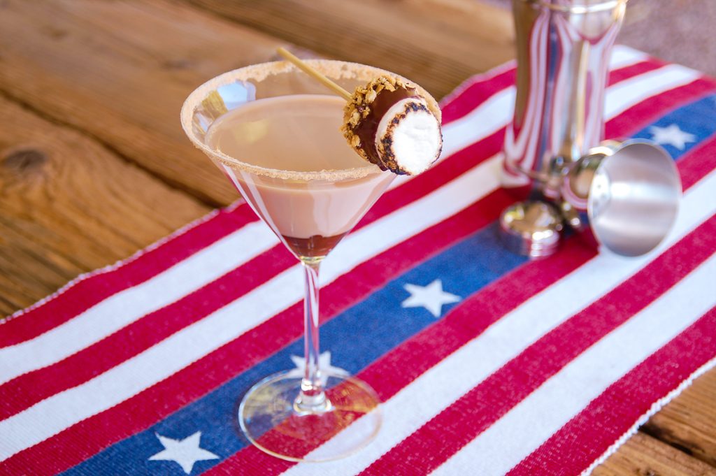 creamy cocktail in martini glass garnished with toasted marshmallow
