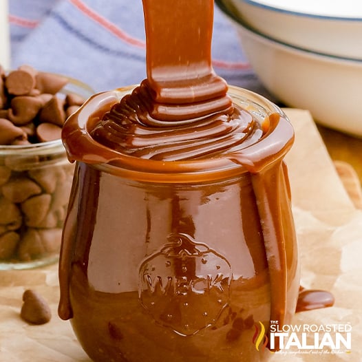 hot fudge sauce pouring from above into glass jar