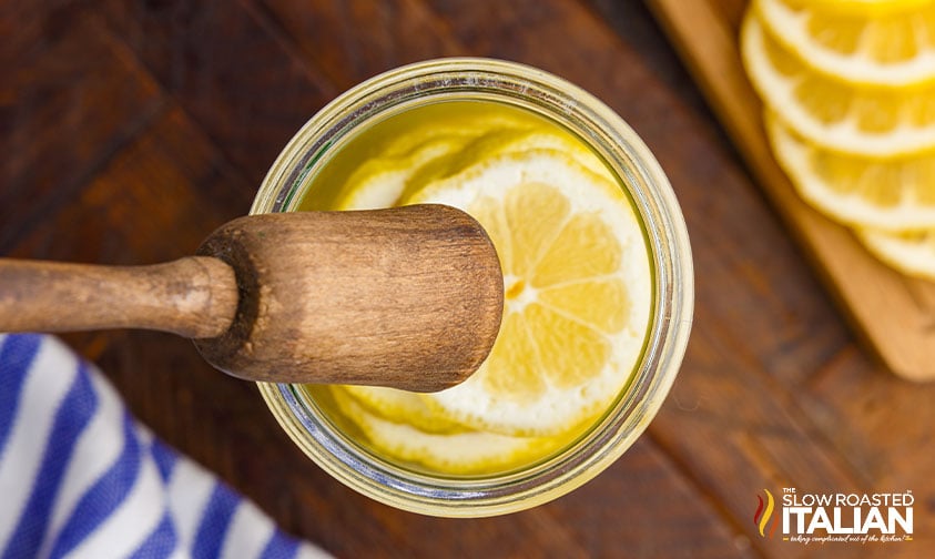 muddling lemons in vodka cocktail