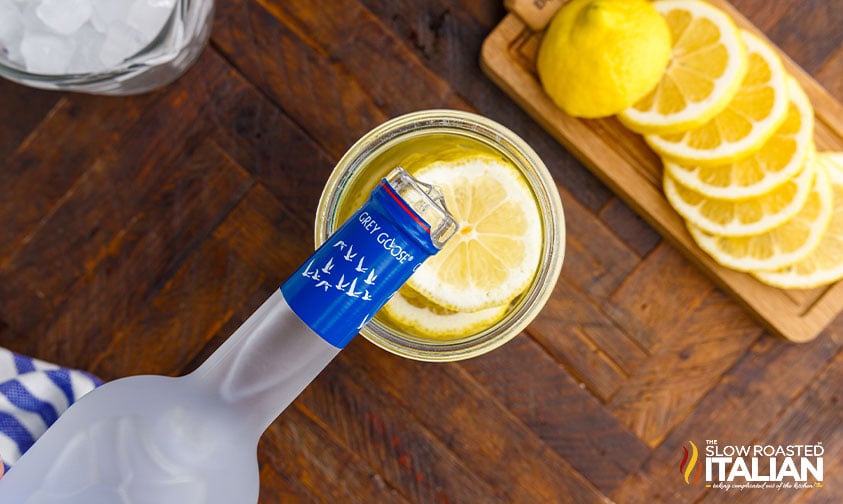 pouring vodka over lemons for spiked lemonade