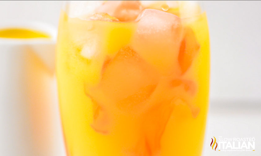 orange drink in tall glass with ice