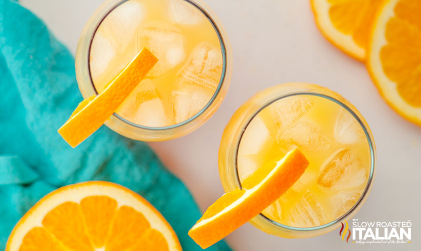 overhead: two tequila cocktails garnished with orange slices