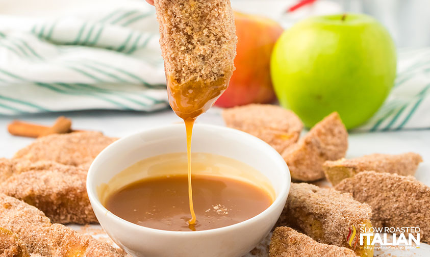 air fryer apple fry dipped in small bowl of caramel sauce