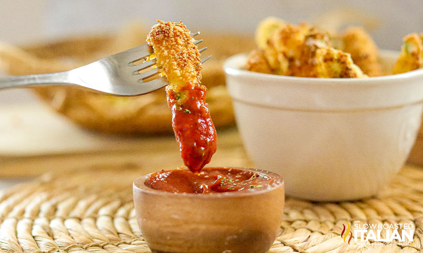zucchini fry on fork dipped in sauce