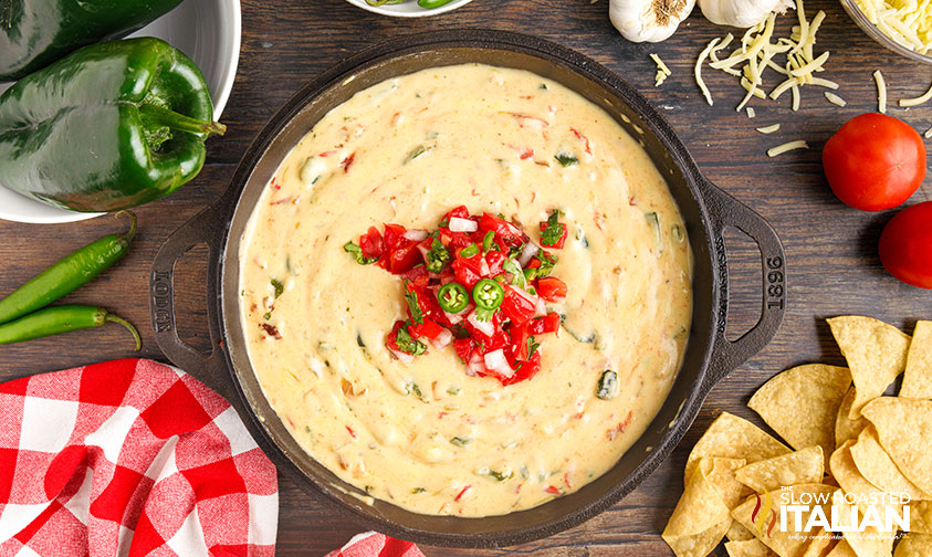 chipotle queso in cast iron pan with ingredients scattered around