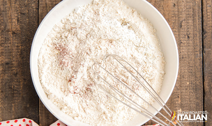 whisk in bowl of seasoned flour