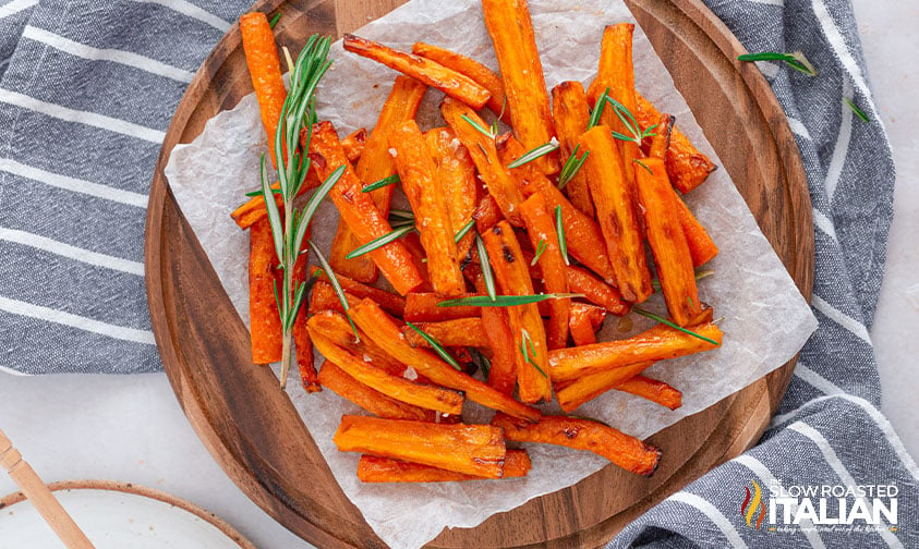 air fryer honey glazed carrot on round board sprinkled with rosemary