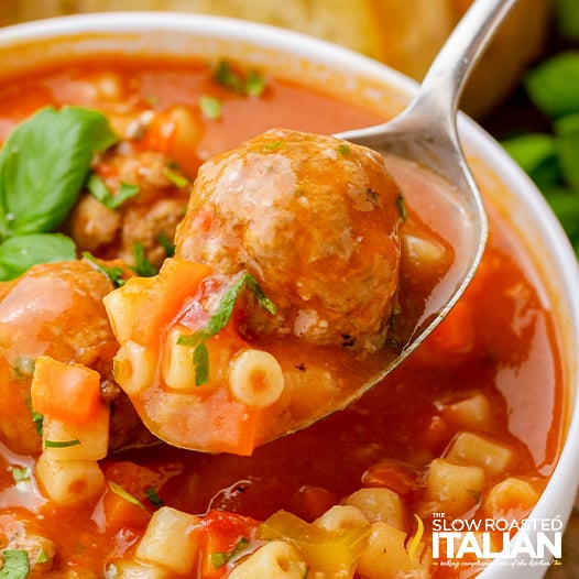 italian meatball soup on spoon above bowl