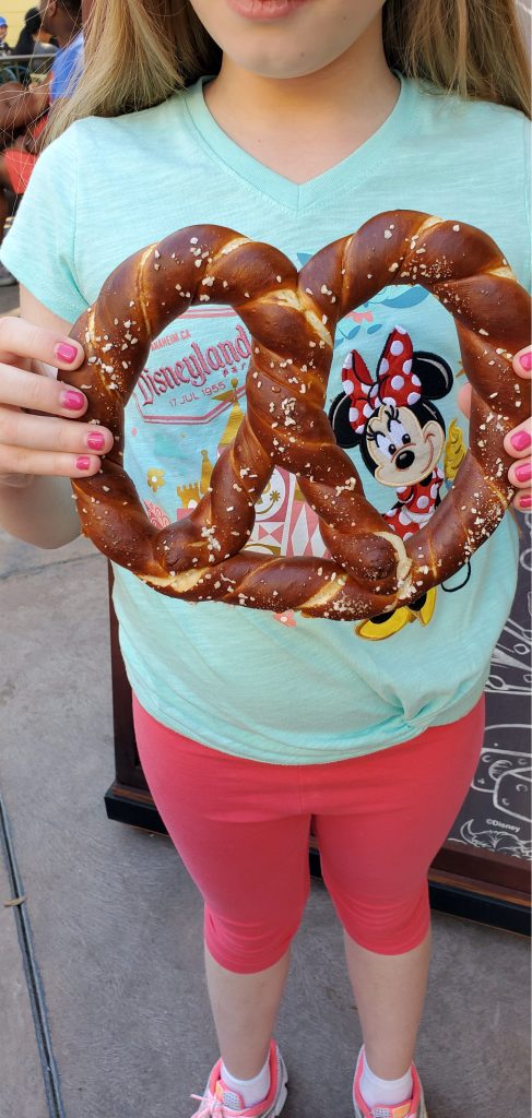 little girl holding a giant soft pretzel