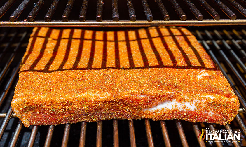 pork belly covered in sweet bbq rub in smoker