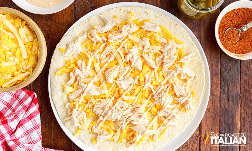 cheese, chicken and queso sauce on tortilla