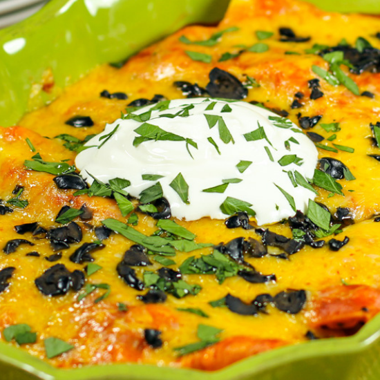 beef and bean enchiladas in green baking dish