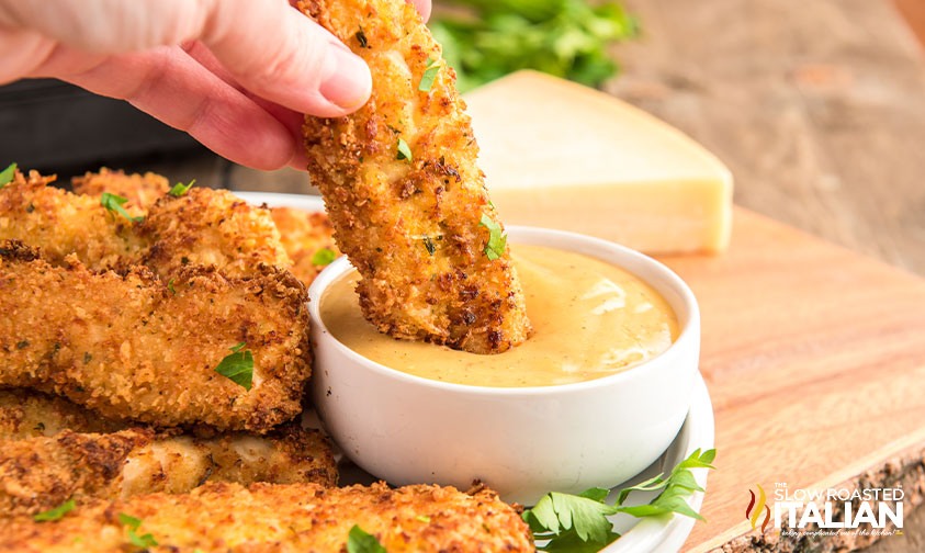 close up of air fryer chicken strips dipped in honey mustard