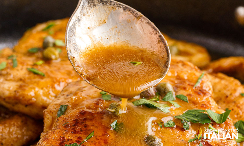 spooning sauce on cheesecake factory chicken piccata