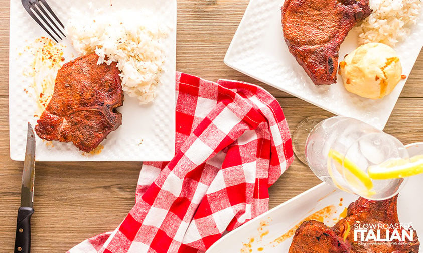 plates with smoked por chops and rice on table