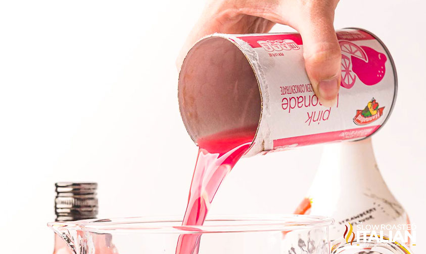 pouring pink lemonade into pitcher