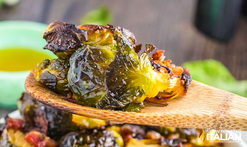 air fryer brussel sprouts with bacon on a wooden spoon.
