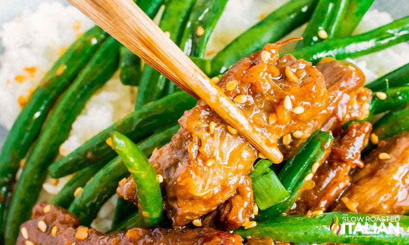 stir fried beef in chopsticks.