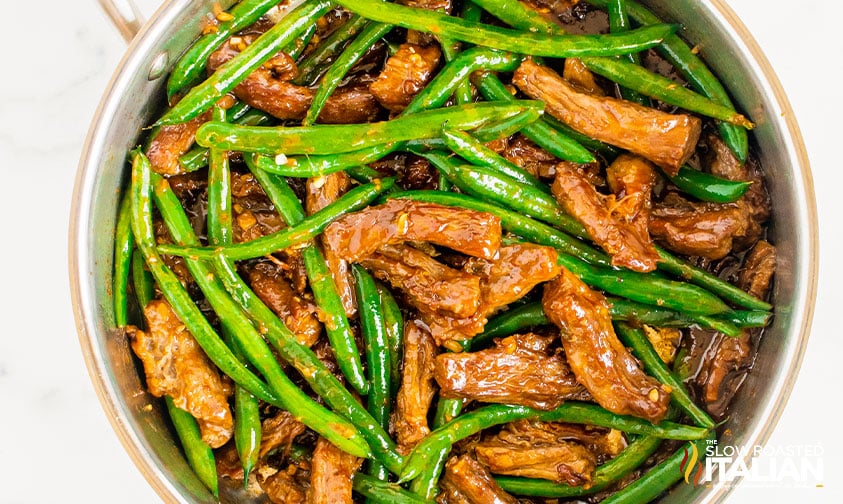 stir fried beef and green beans in skillet.