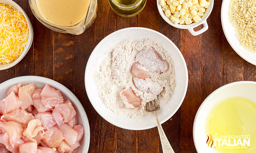breading pieces of boneless skinless chicken in seasoned flour.