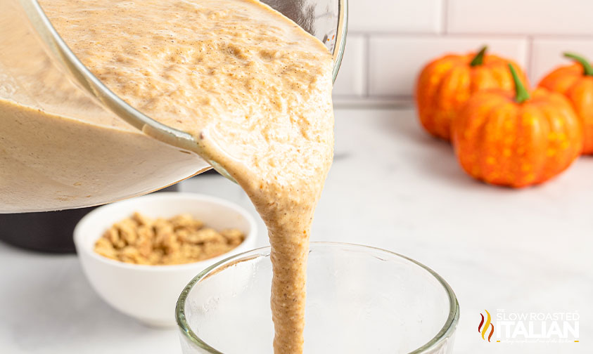 pouring pumpkin milkshake in glass.