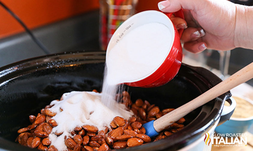 pouring sugar over almonds.