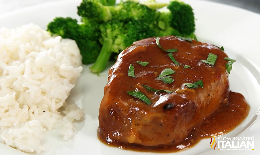crockpot pork chops with gravy on a plate.