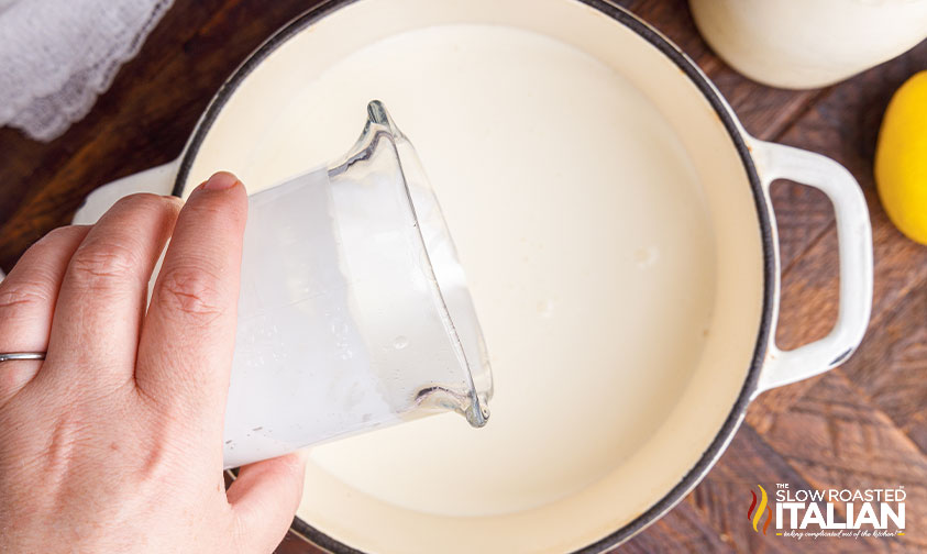 pouring heavy cream into pot.