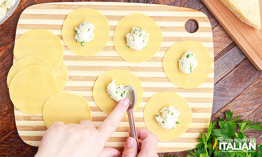 adding ricotta filling to fresh tortellini.